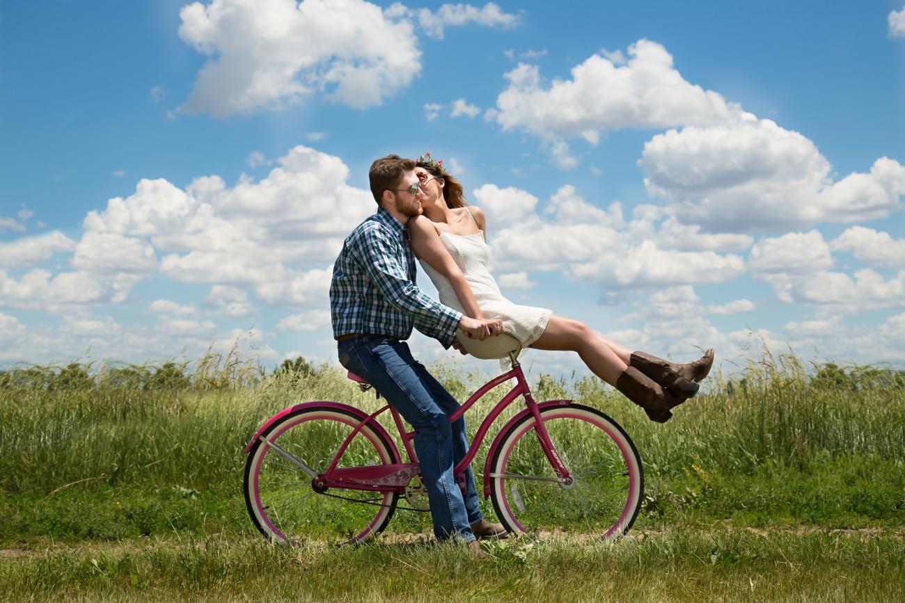 Happy couple on a bike enjoying each other after postponing wedding
