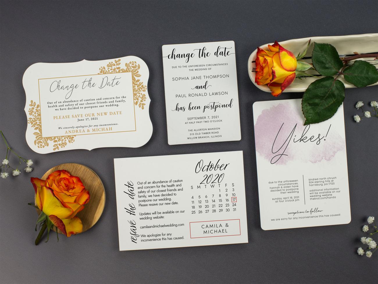 4 wedding change the date cards placed out on a table. Decorated with beautiful rose flowers