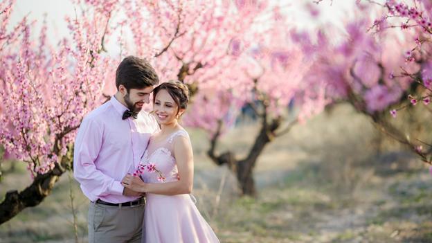 a beautiful wedding couple in the gardens of a blossoming peach