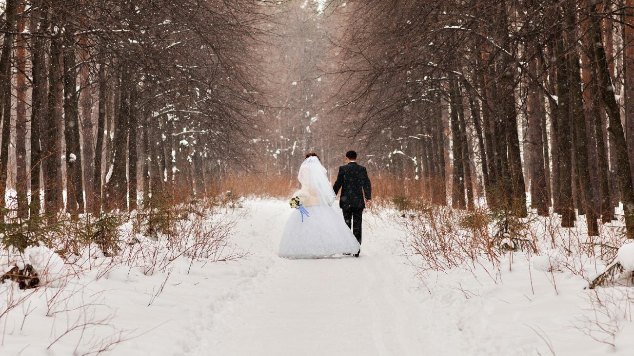 a bride and groom outdoors in the snow during winter wedding