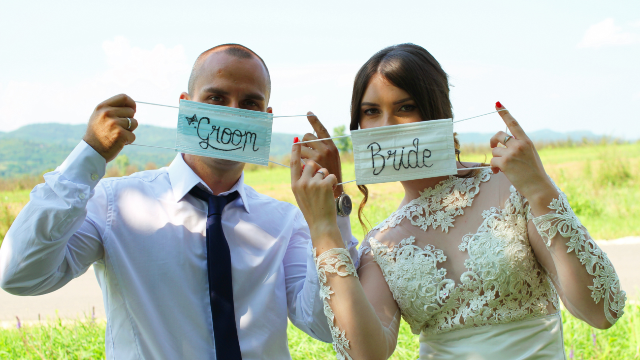 a bride and groom wear masks displaying bride and groom inscriptions on wedding day
