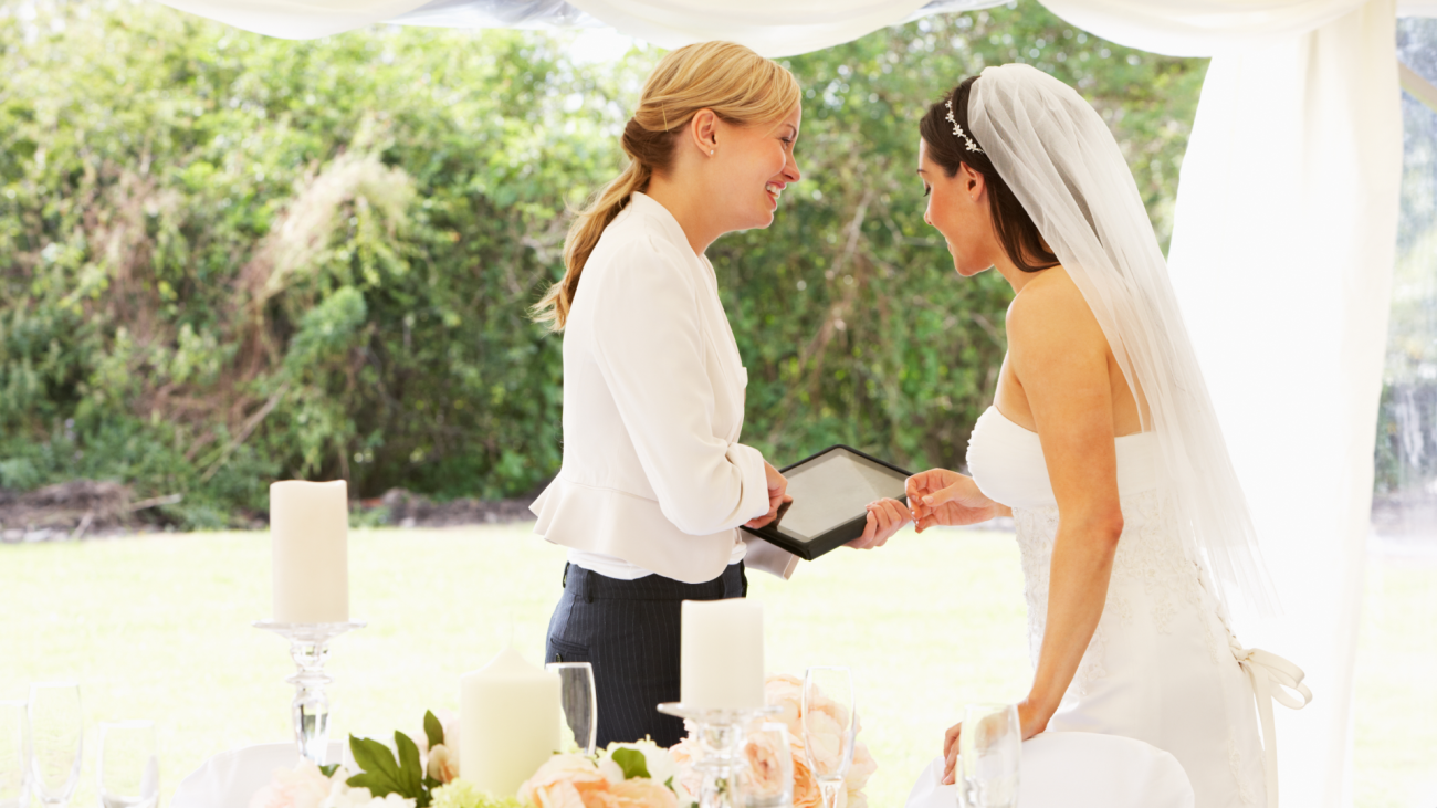 a bride speaking with wedding planner in a marquee