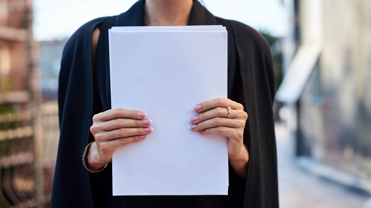 a business woman holds sheets of paper