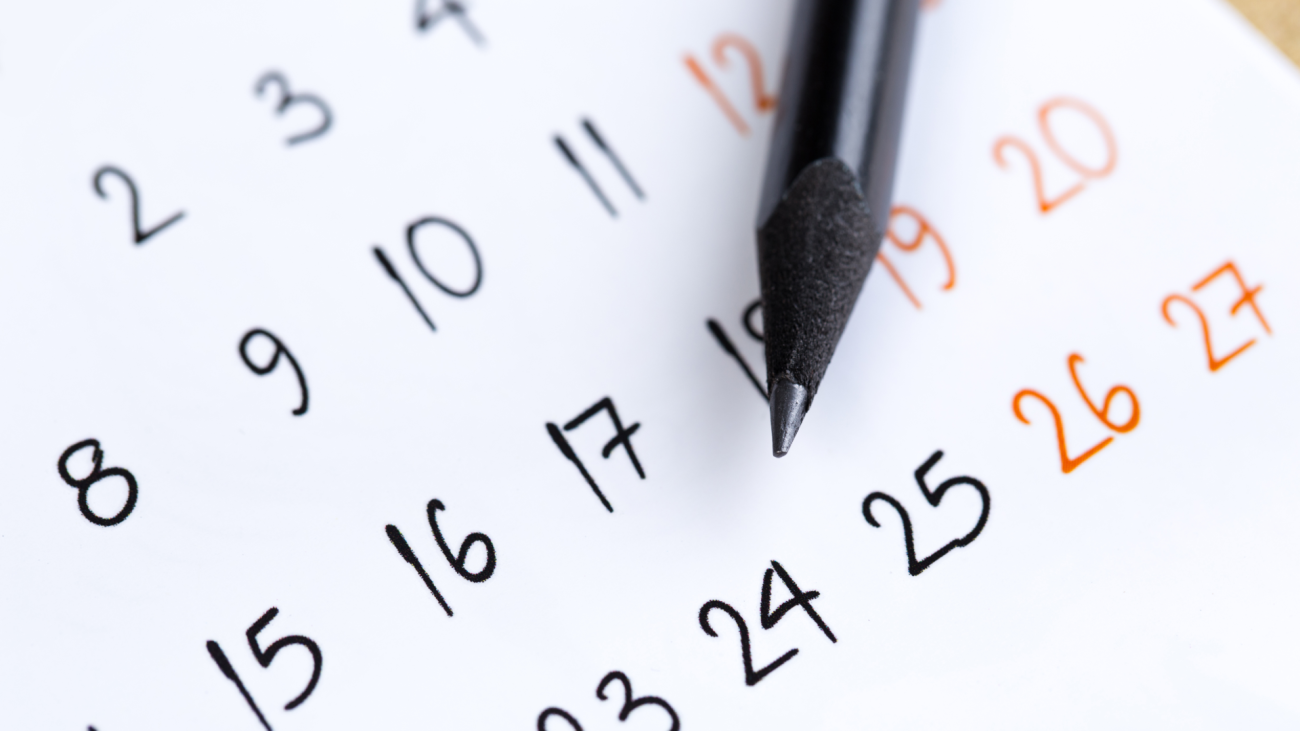a calendar with a pen pointed at the 24th date
