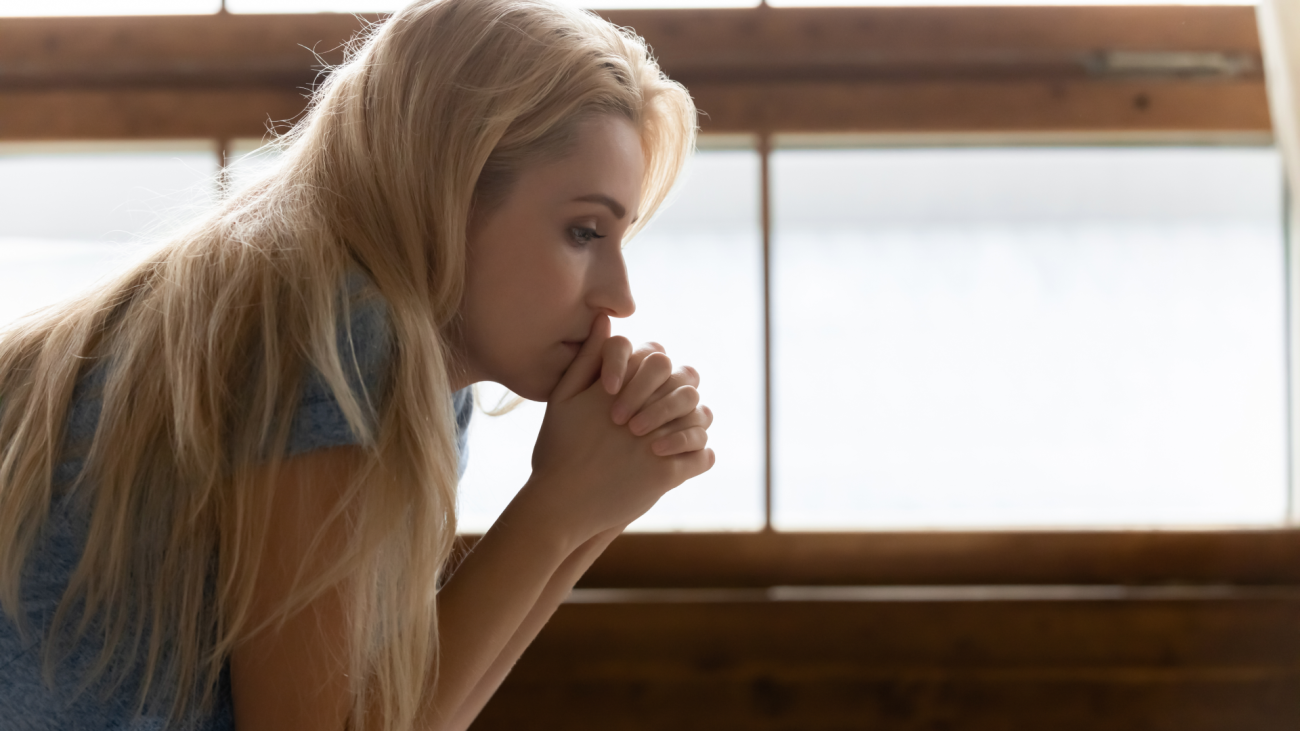 a distraught woman puts her face in her hands