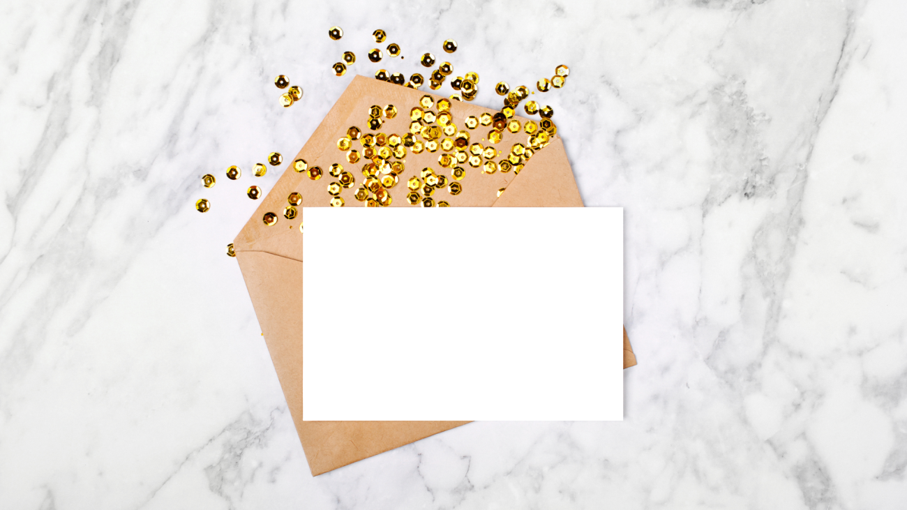 a blank card sitting on an envelope and gold confetti