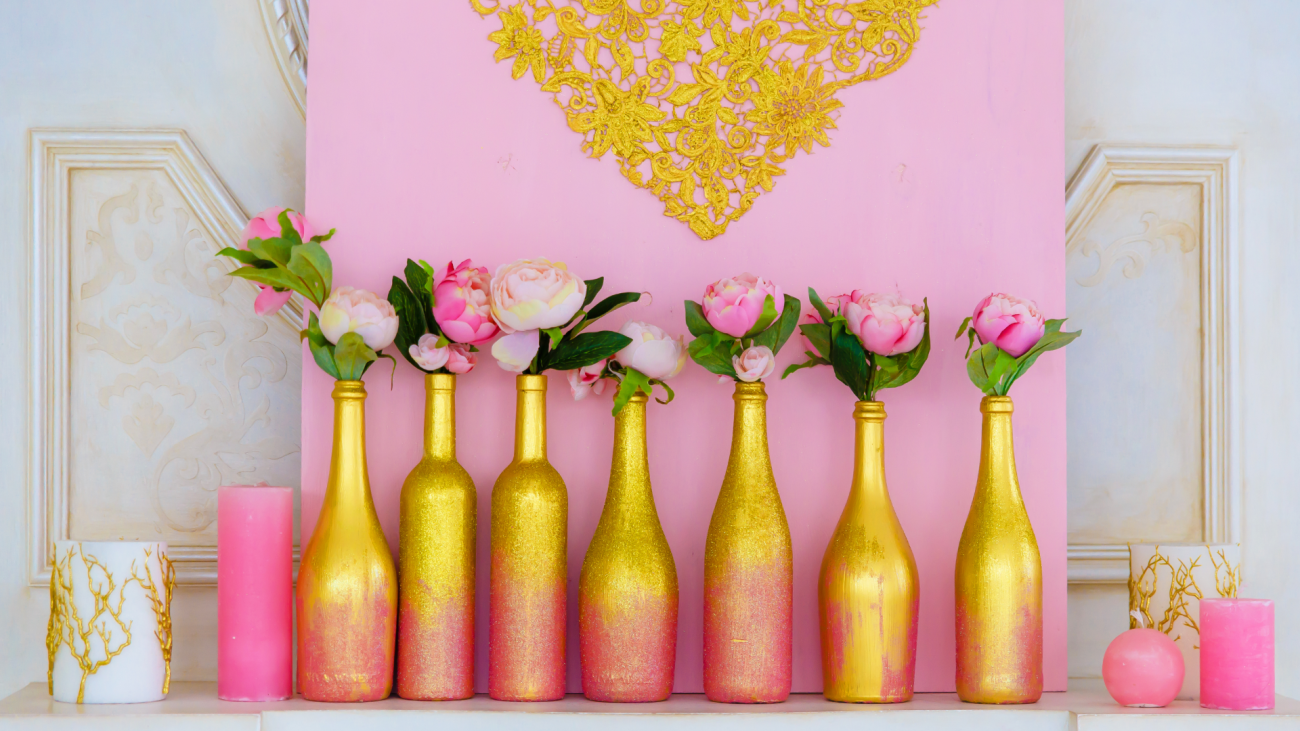 flowers sitting in seven wine bottles that are painted yellow and pink