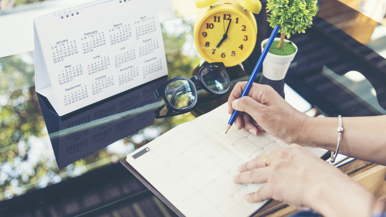 a person looks at two calendars on their desk