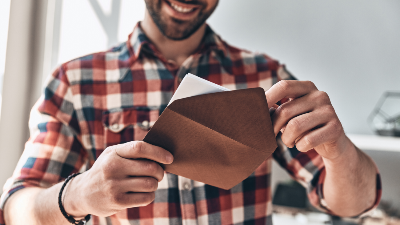 a man opens an envelope and smiles