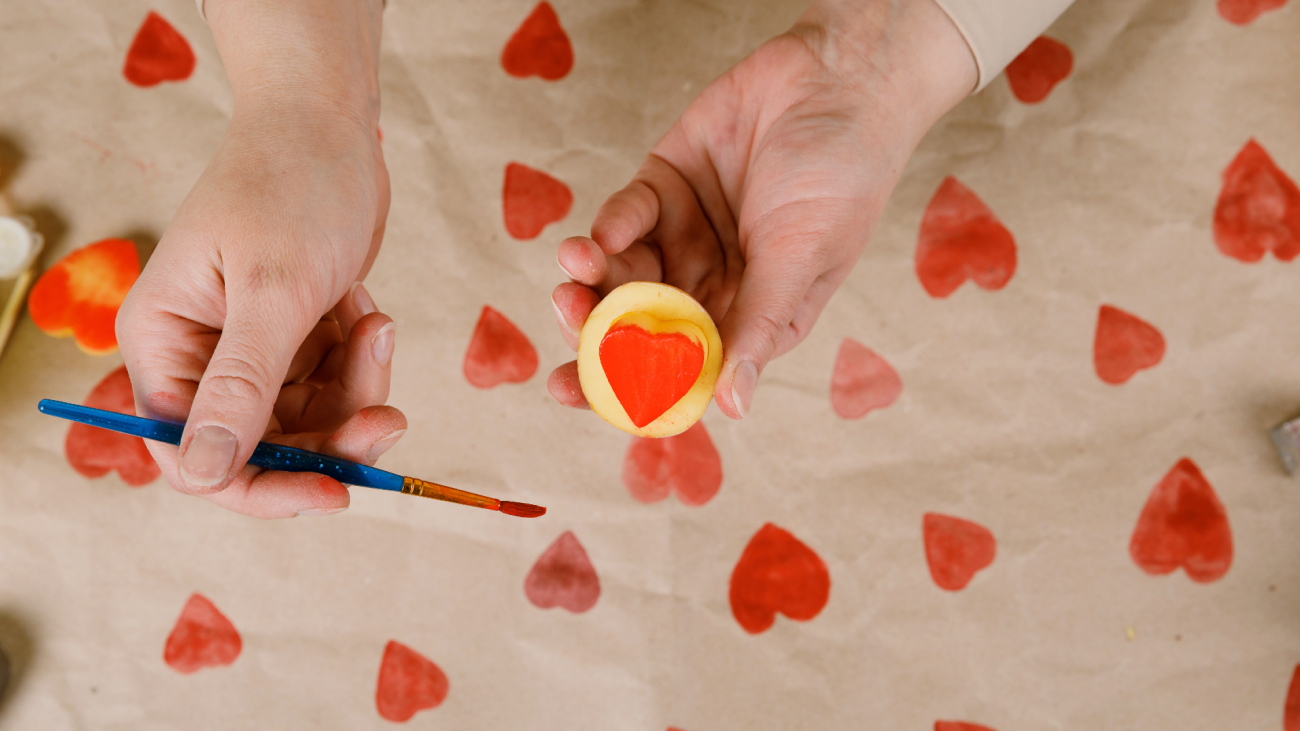 a person paints on a DIY heart-shaped potato stamp
