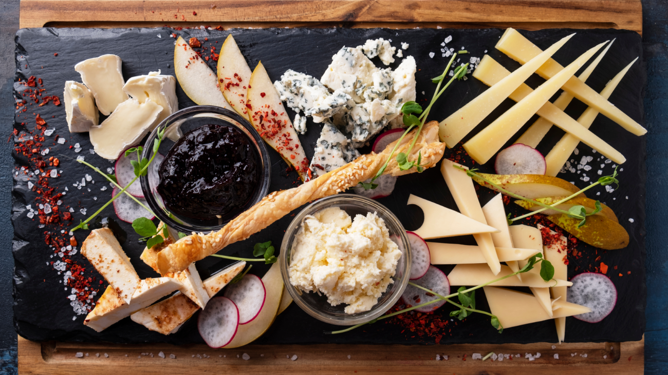 a cheese plate served with jam and pears