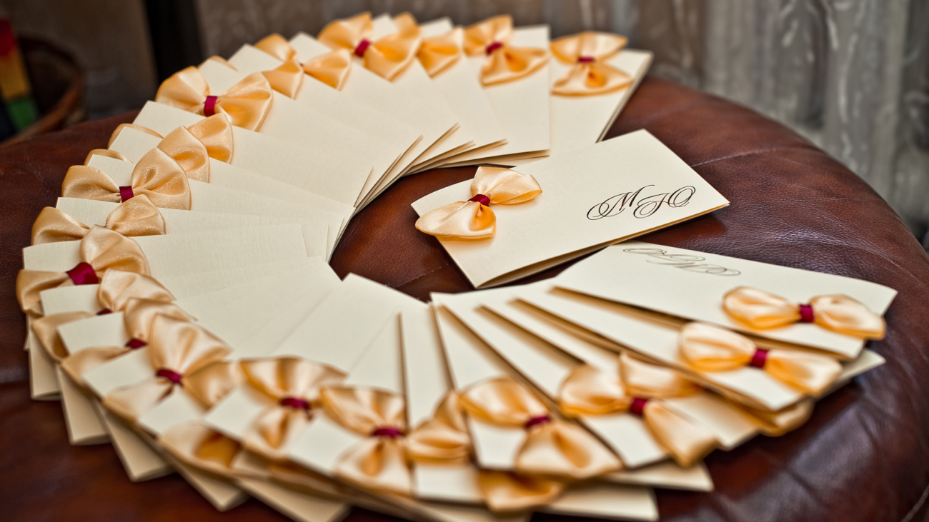 a set of wedding invitations decorated with bows before they are labeled with addresses