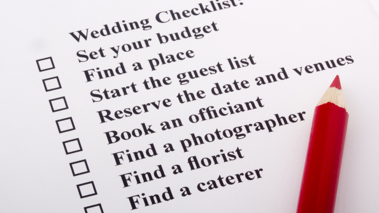 a red pencil lays on a wedding checklist