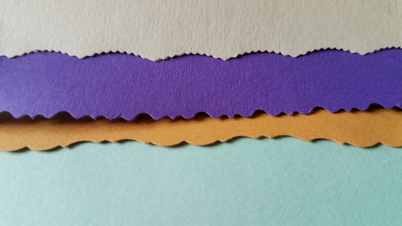 four different colors of paper with scalloped edges