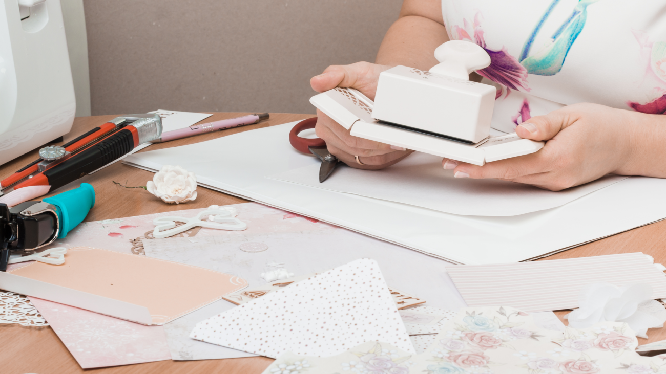 person working with scrapbooking tools at her desk