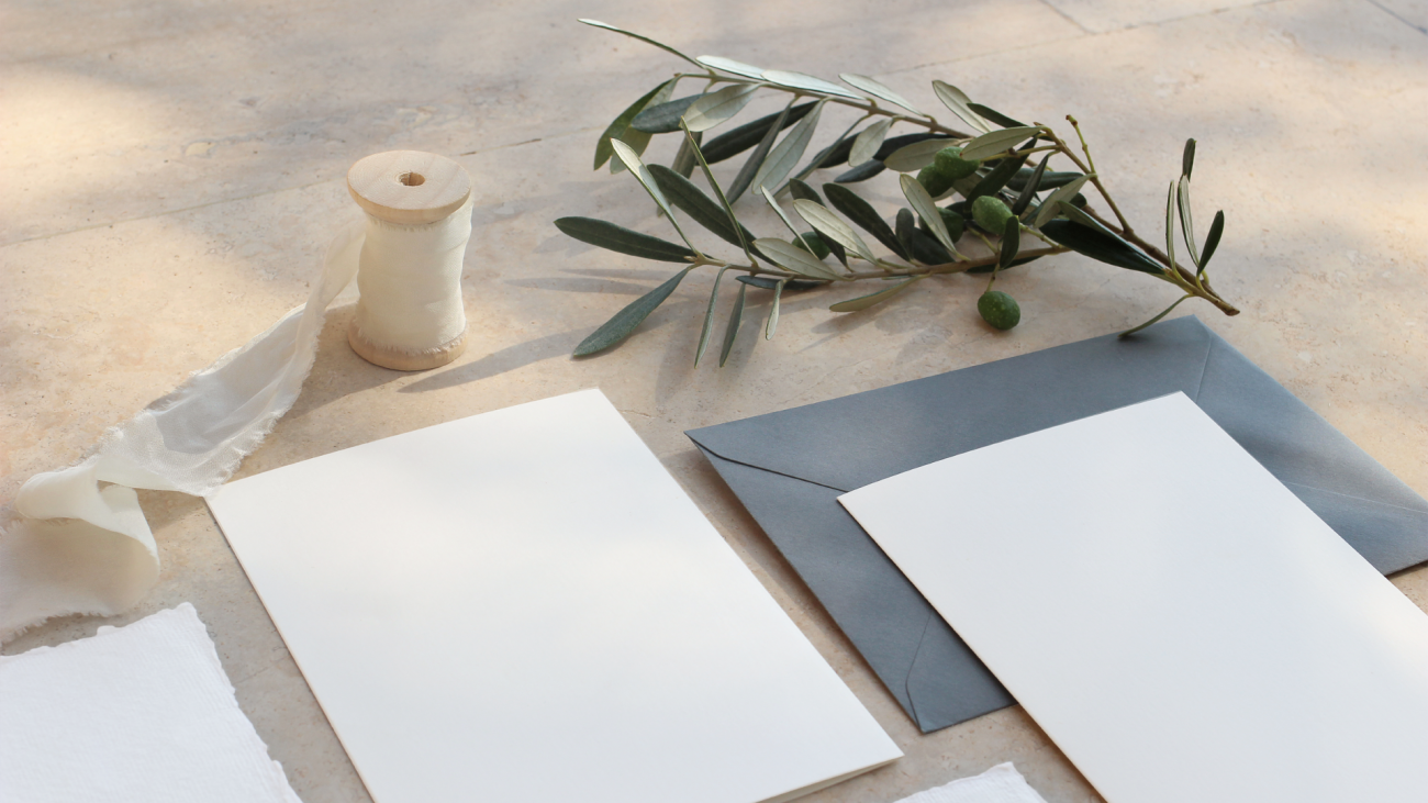 a summer wedding stationery mockup featuring a branch, envelopes, and ribbons