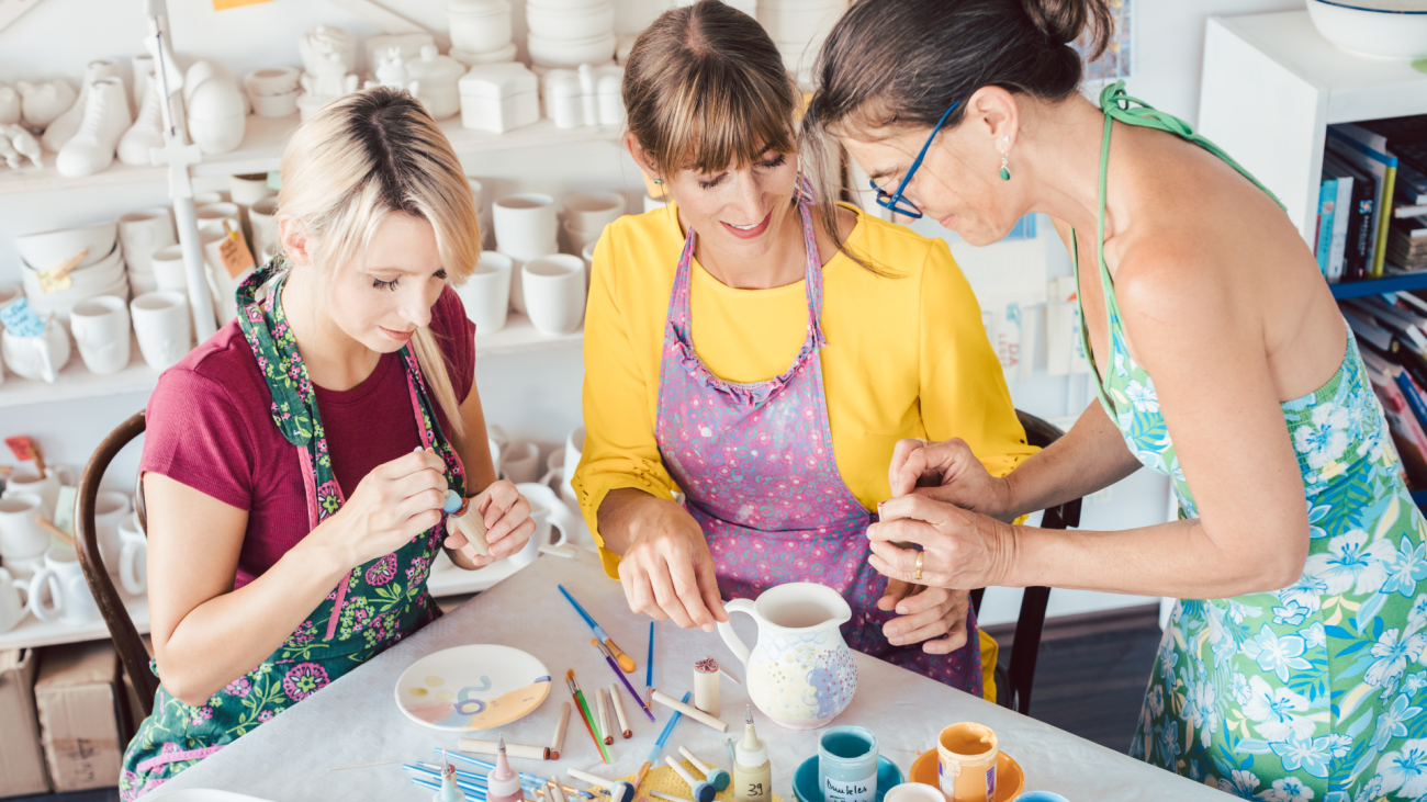 three women do arts and crafts project at a table