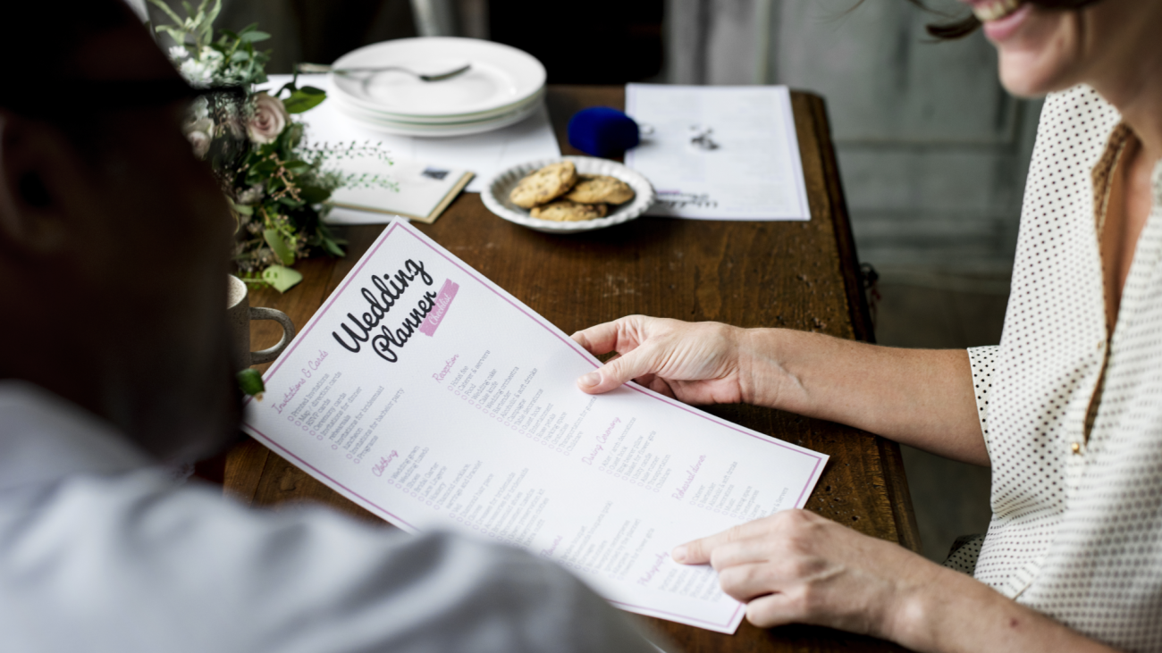 two people hold and review a wedding checklist