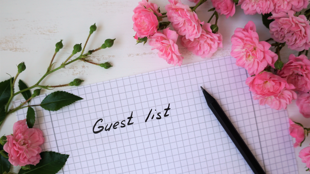a wedding guest list with roses on top