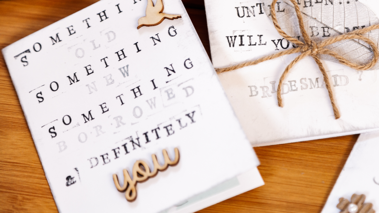 embellished wedding invitation with “something old, something new, something borrowed, & definitely you” labeled on the front