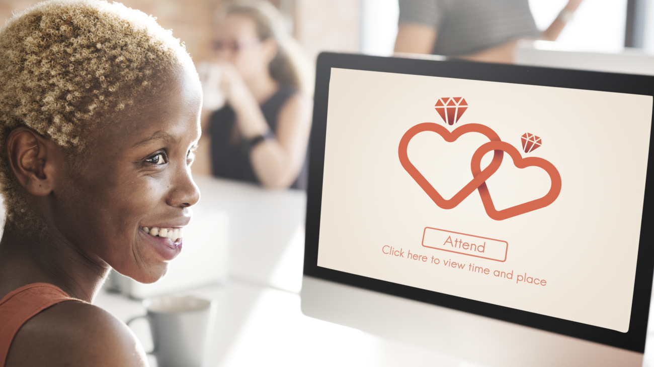 a woman looks at a digital RSVP invite for a wedding, featuring a graphic of two heart-shaped rings