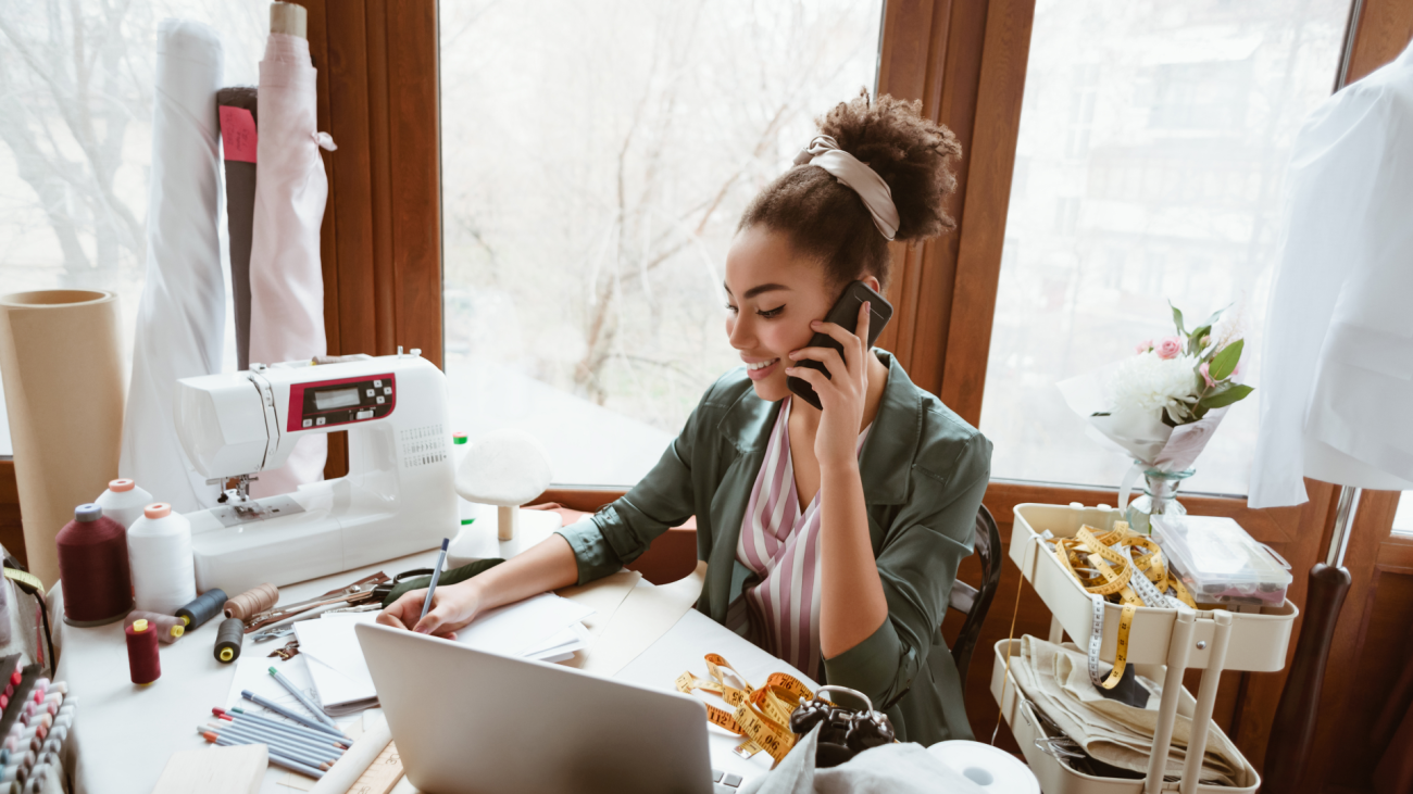 a woman talks on the phone next to a sewing machine
