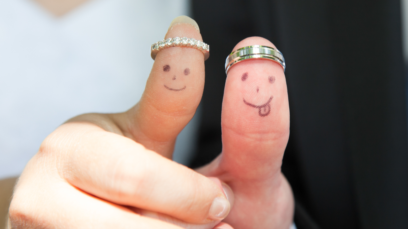 newlyweds displaying thumbs with wedding rings and smiley faces