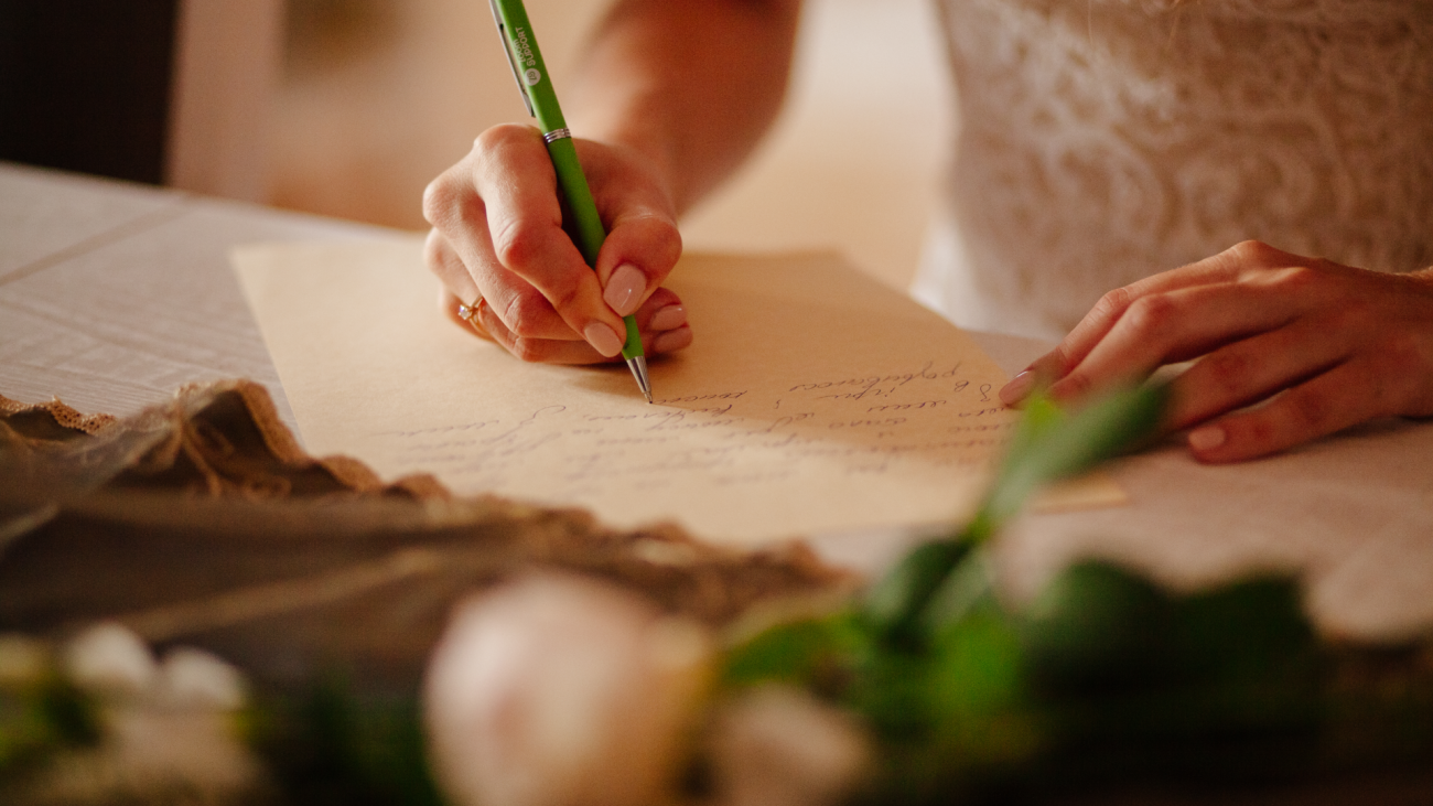 a close-up of a bride writing her wedding vows