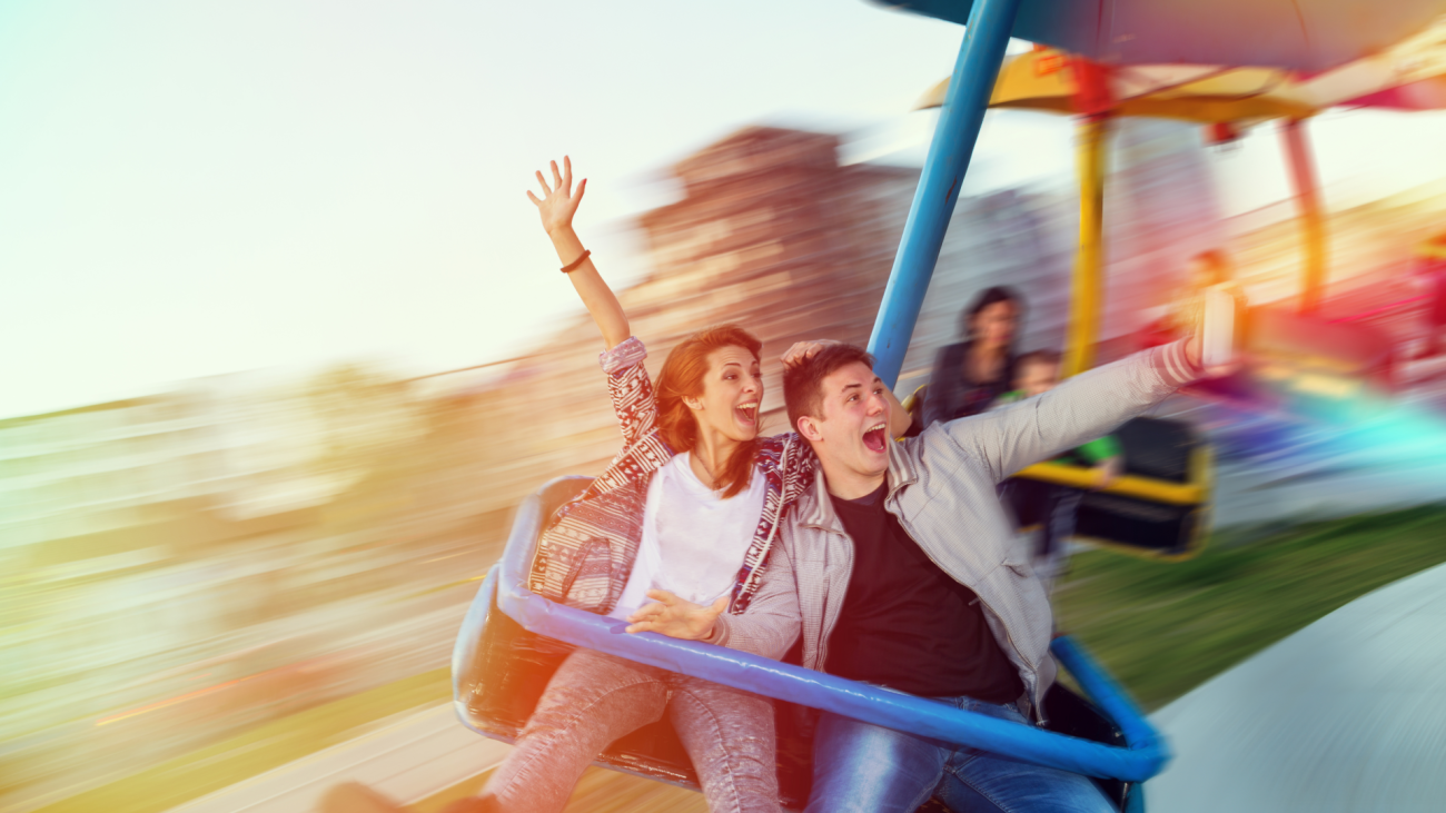 a couple has fun on an amusement park swing