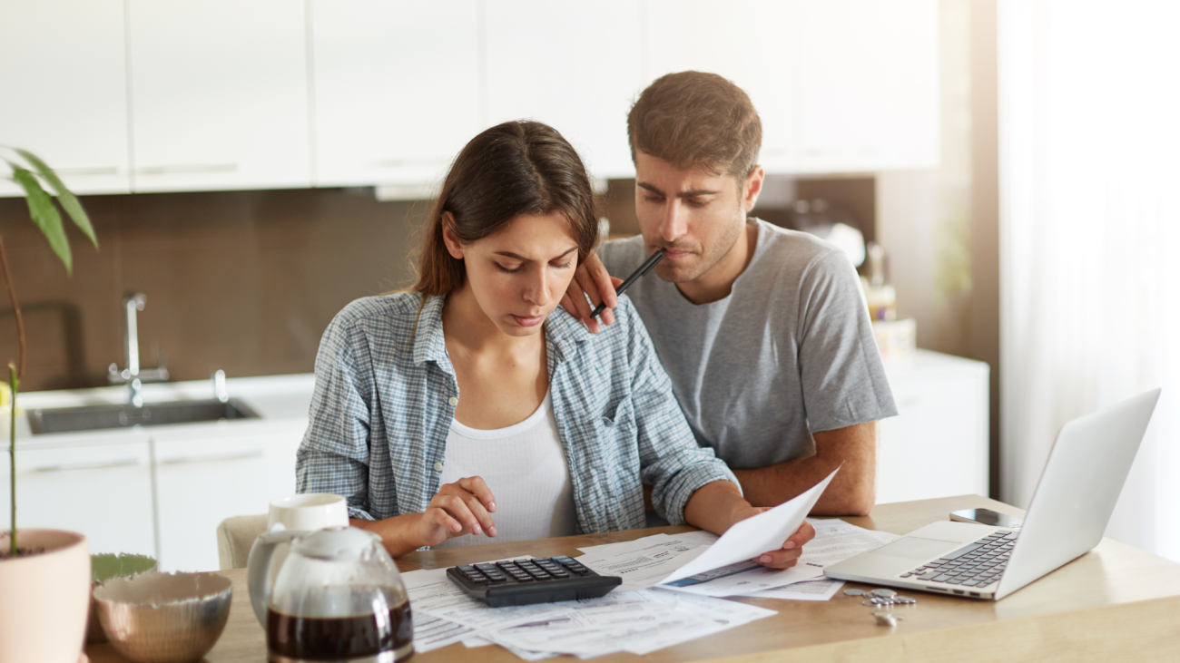 a couple calculates their wedding budget on the kitchen counter