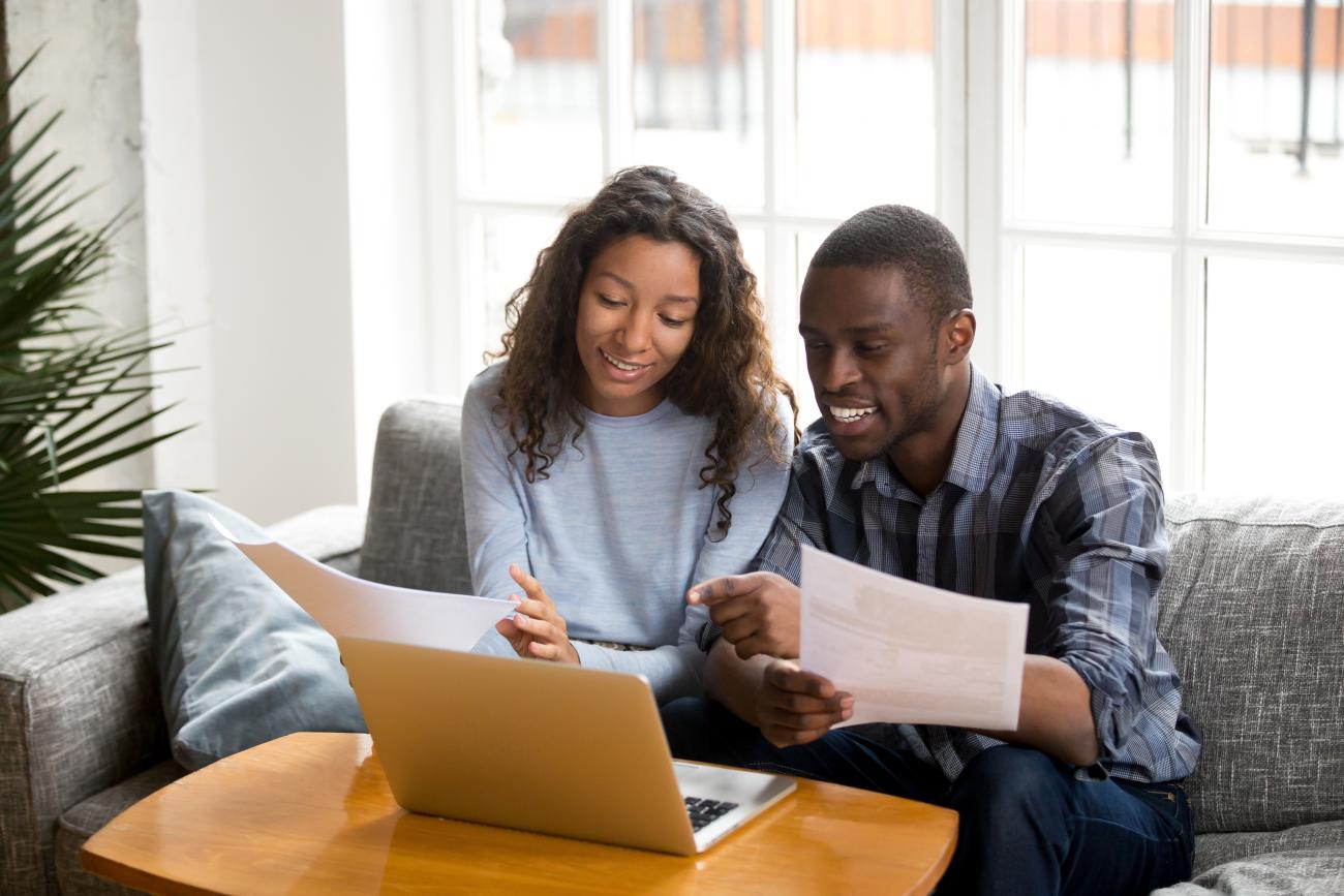 Couple sitting in front of their computer discussing their wedding budget