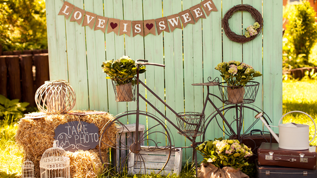 love is sweet” banner, watering can, hay, and photo ops
