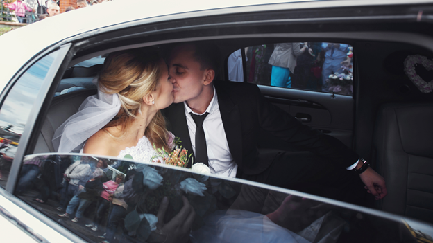 newlyweds kiss in a wedding limo