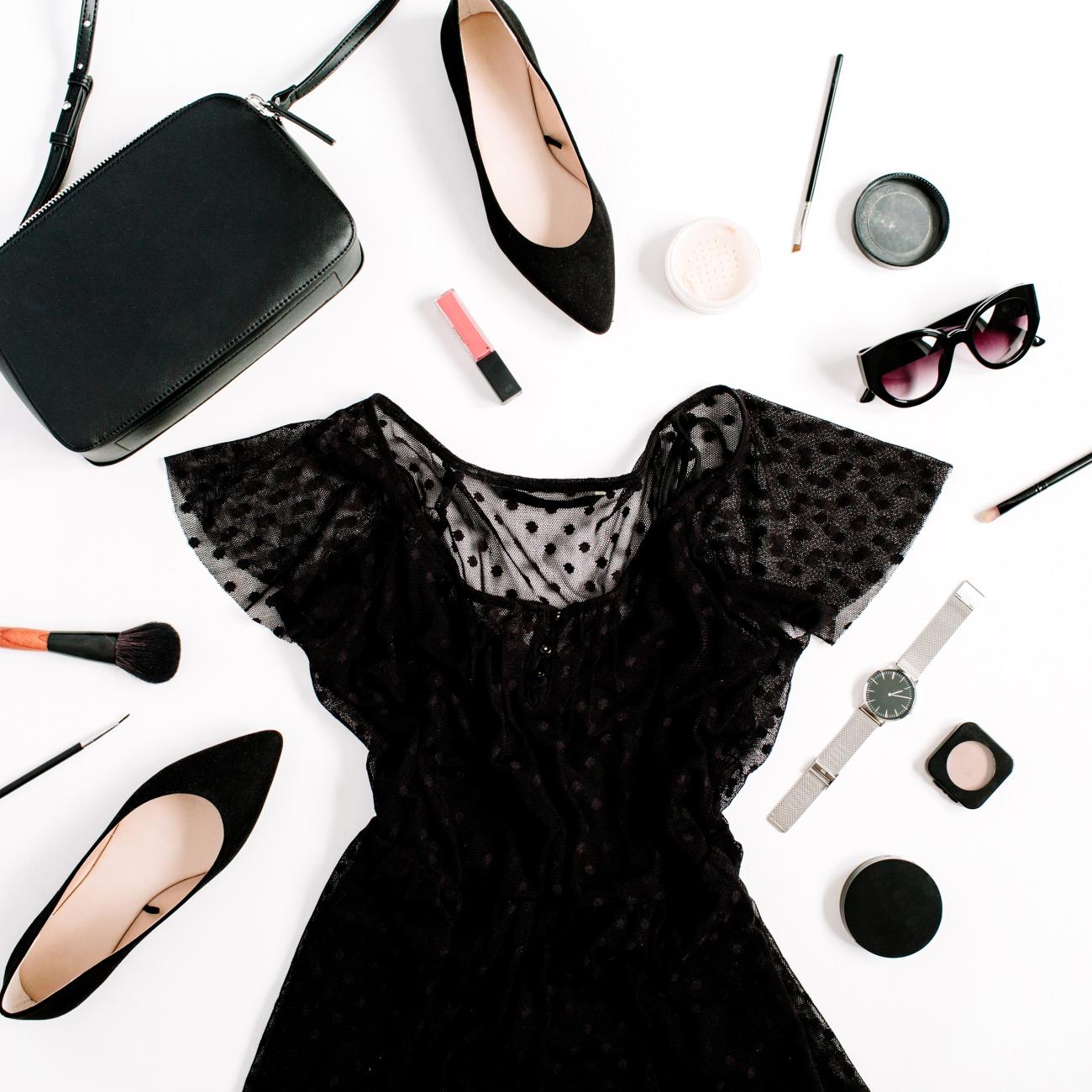 Flatlay with black dress, shoes, purse, and makeup