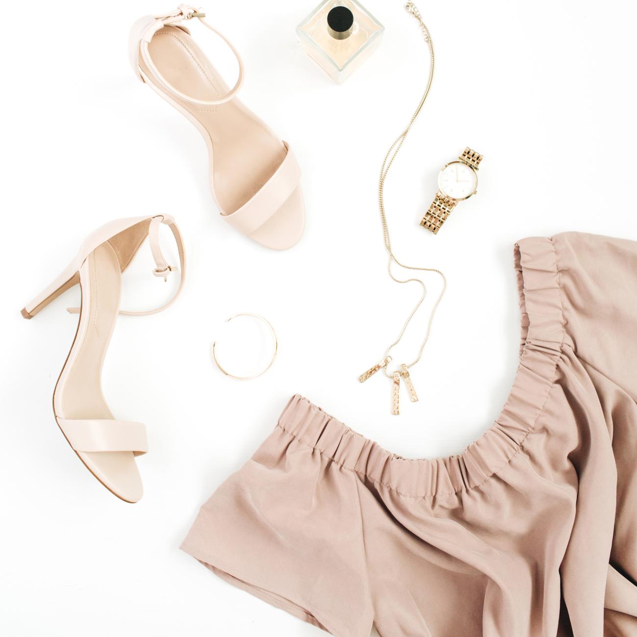 Flatlay with dress, heels, necklace, bracelet, and perfume.