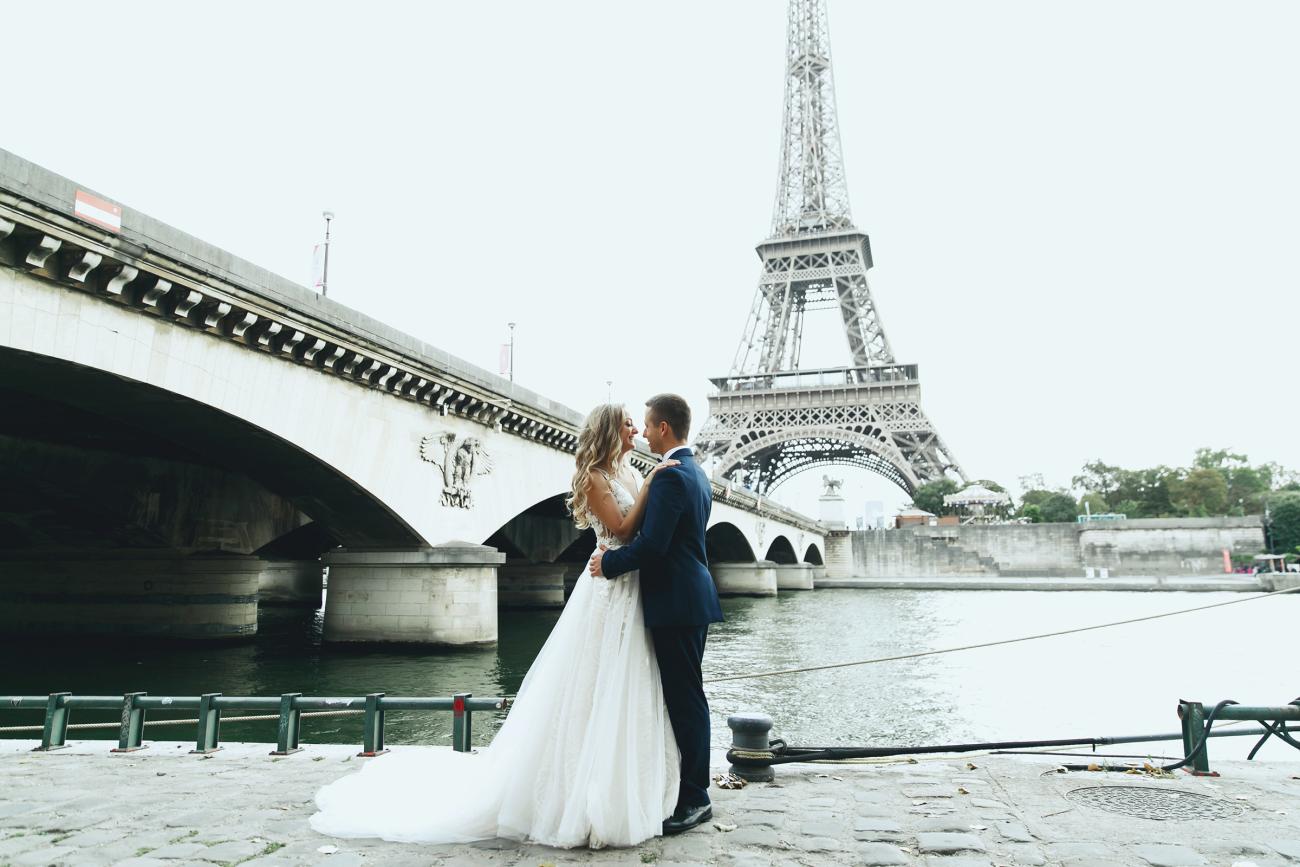 Bride and groom embracing in Paris with the Eiffel Tower in the background