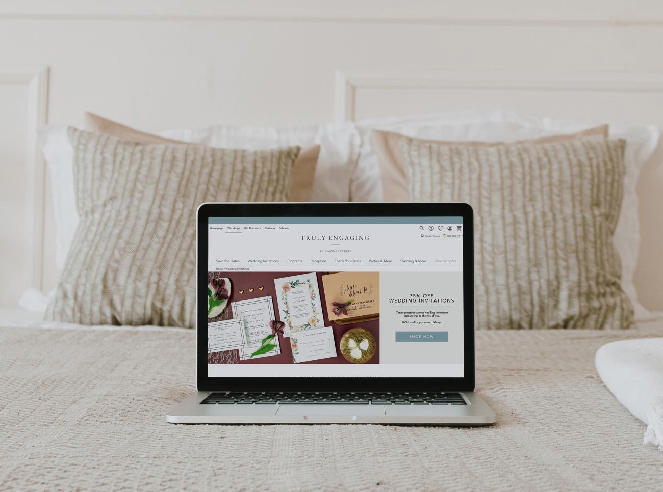 laptop with truly enaging website on screen sitting on top of pretty bed
