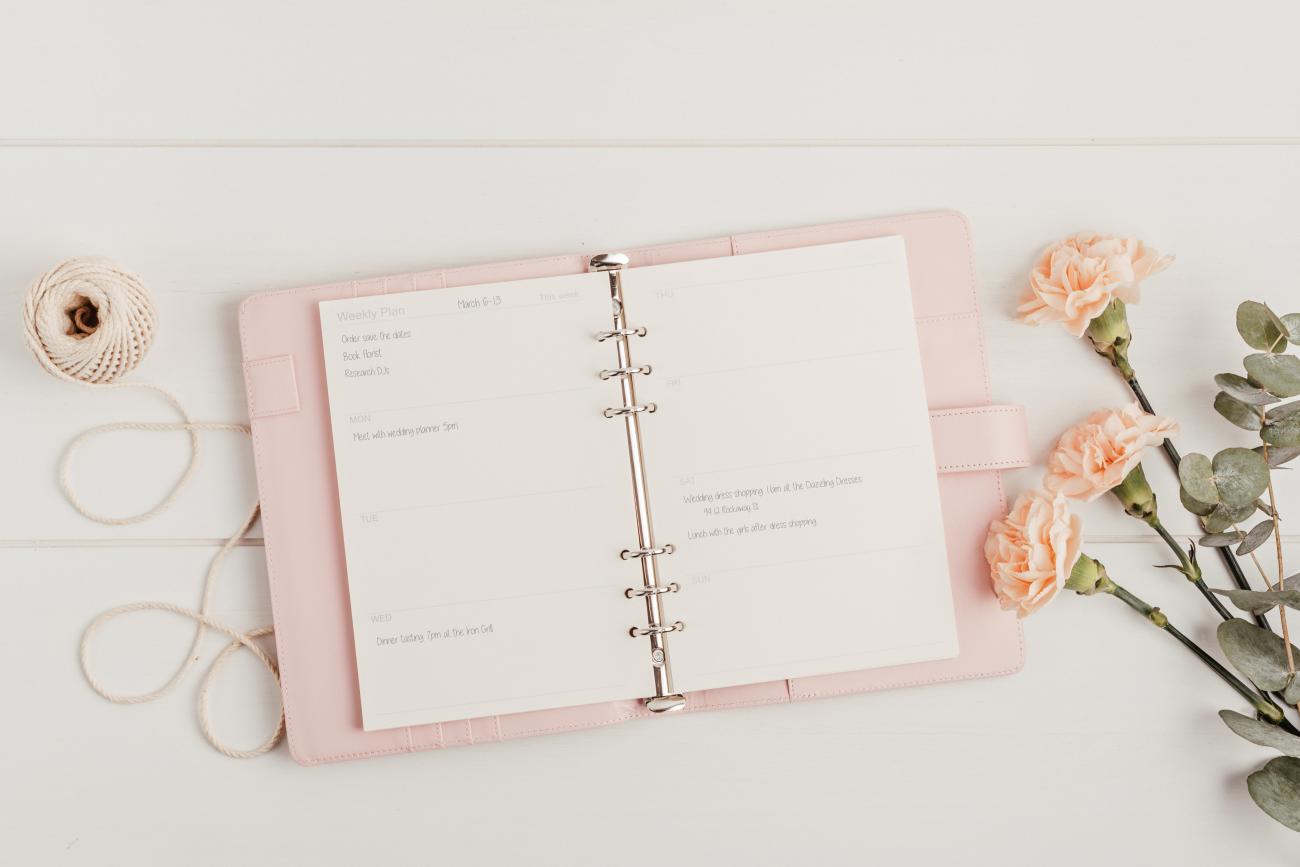 Wedding planner book laying open to a page with writing on it