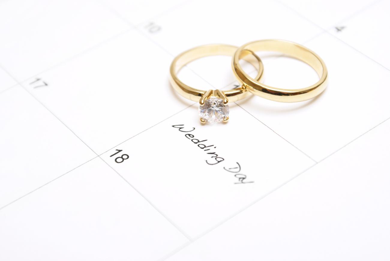 wedding rings on calendar with wedding date highlighted