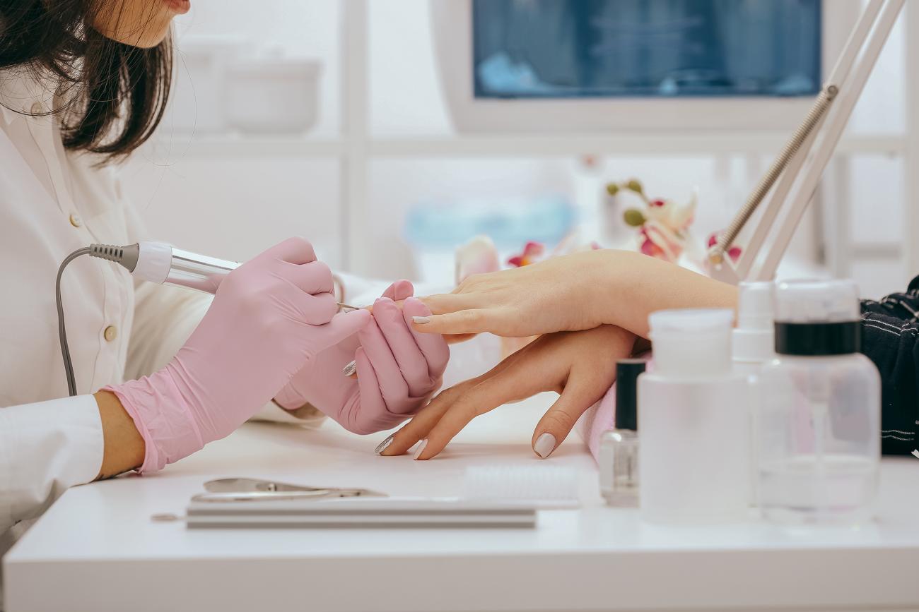 Woman getting her nails done by a professional