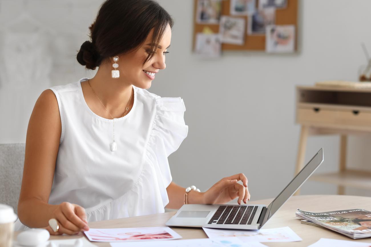 Woman on laptop happily planning a wedding