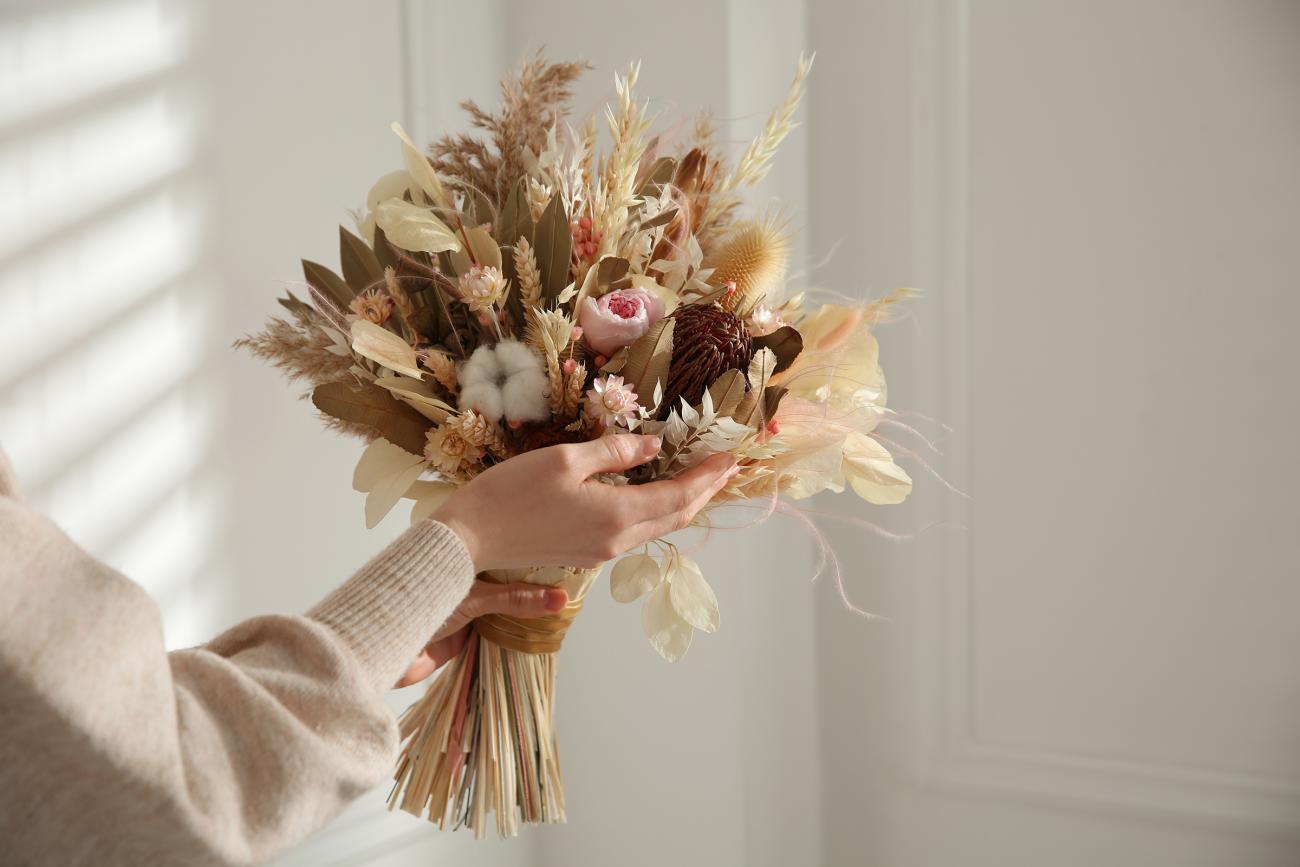 Woman putting together a bouquet with dried florals