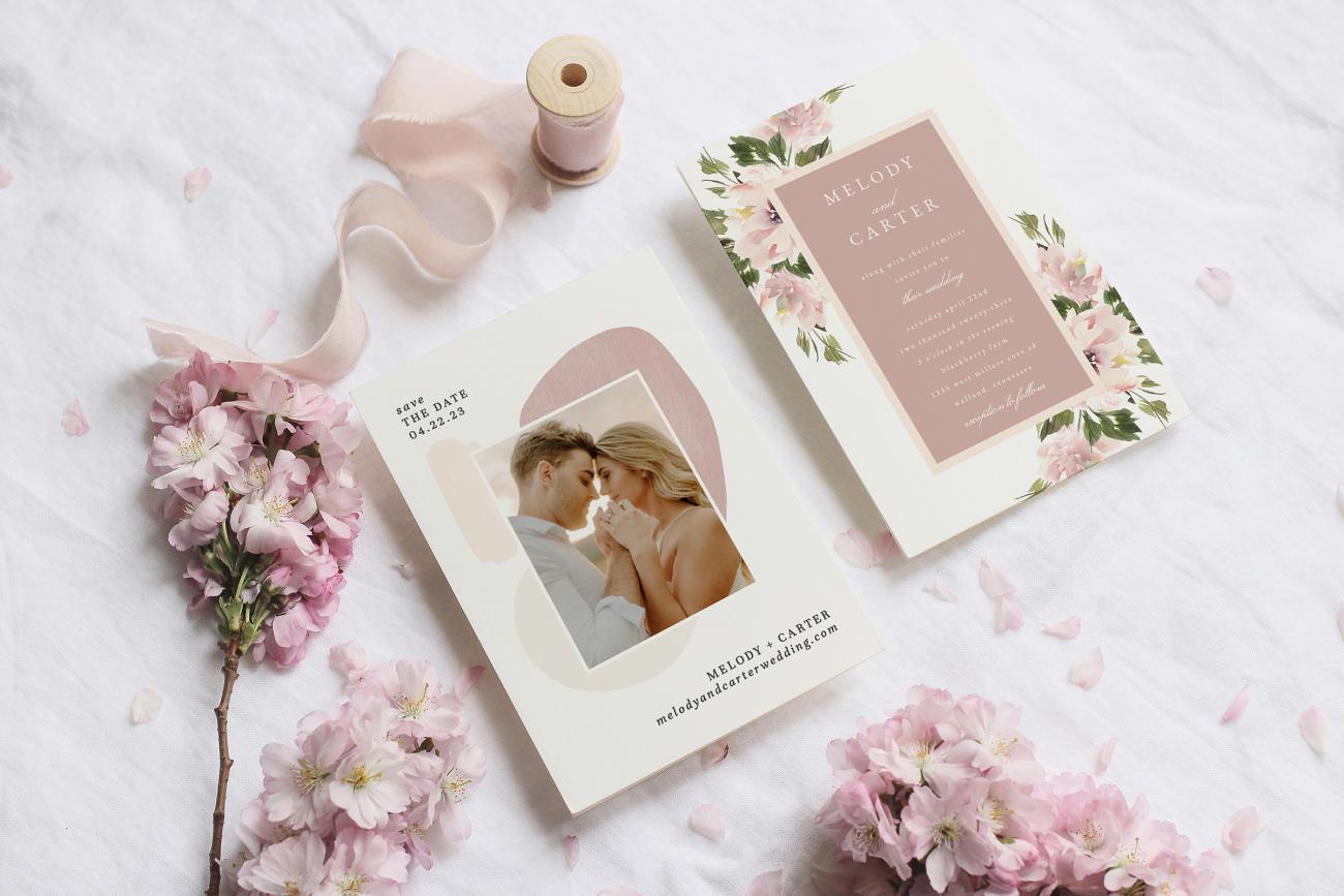 Beautiful wedding invitation and save the date surrounded by flowers and ribbon