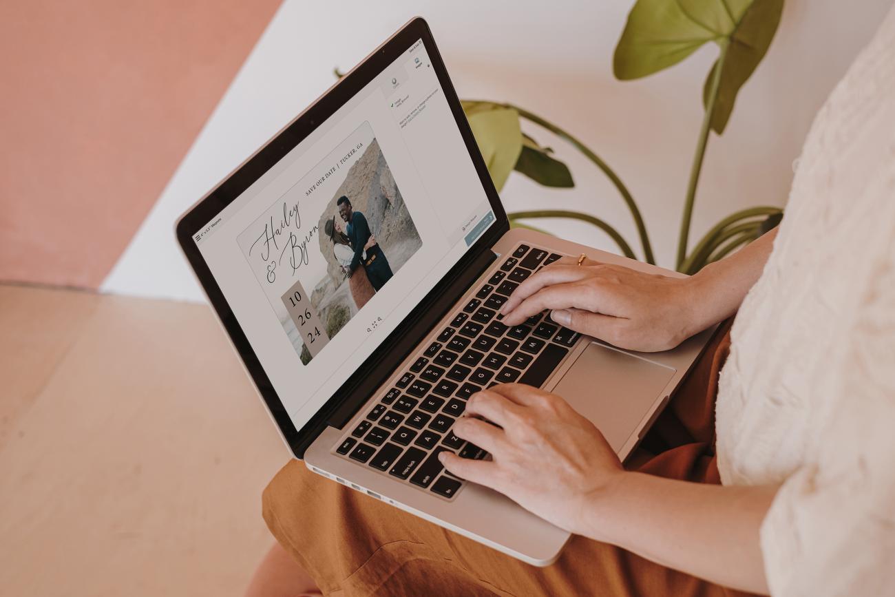 Woman on laptop working on her uploaded save the date