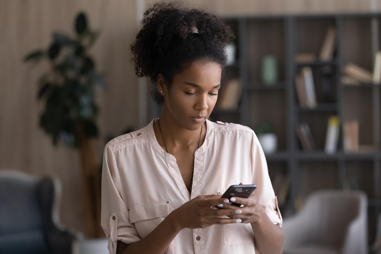 Woman using cell phone to send text message