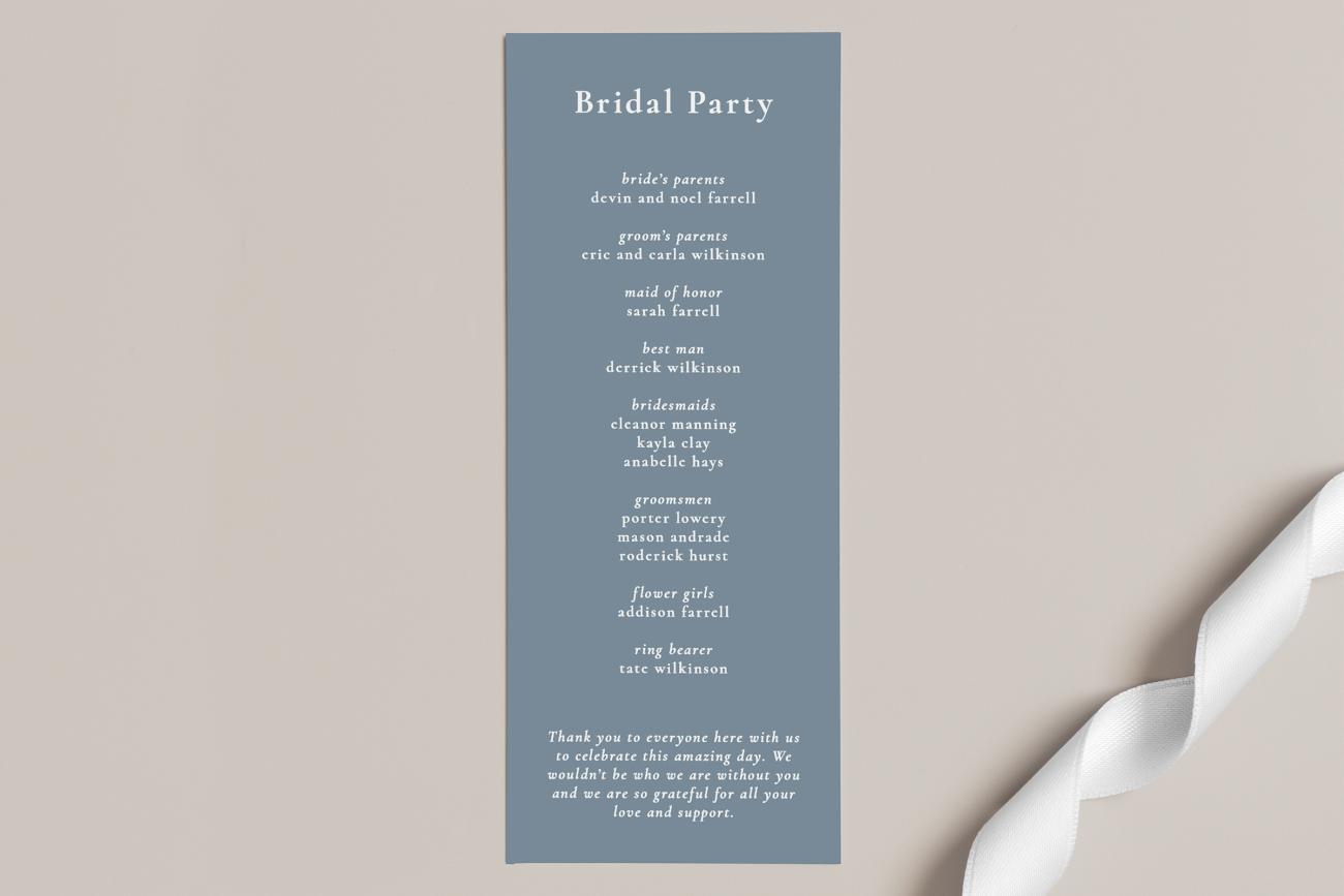 Tea length wedding program next to white ribbon