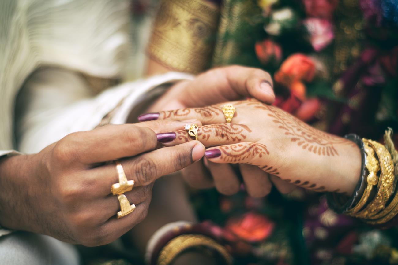 Cultural wedding groom giving bride ring ceremony