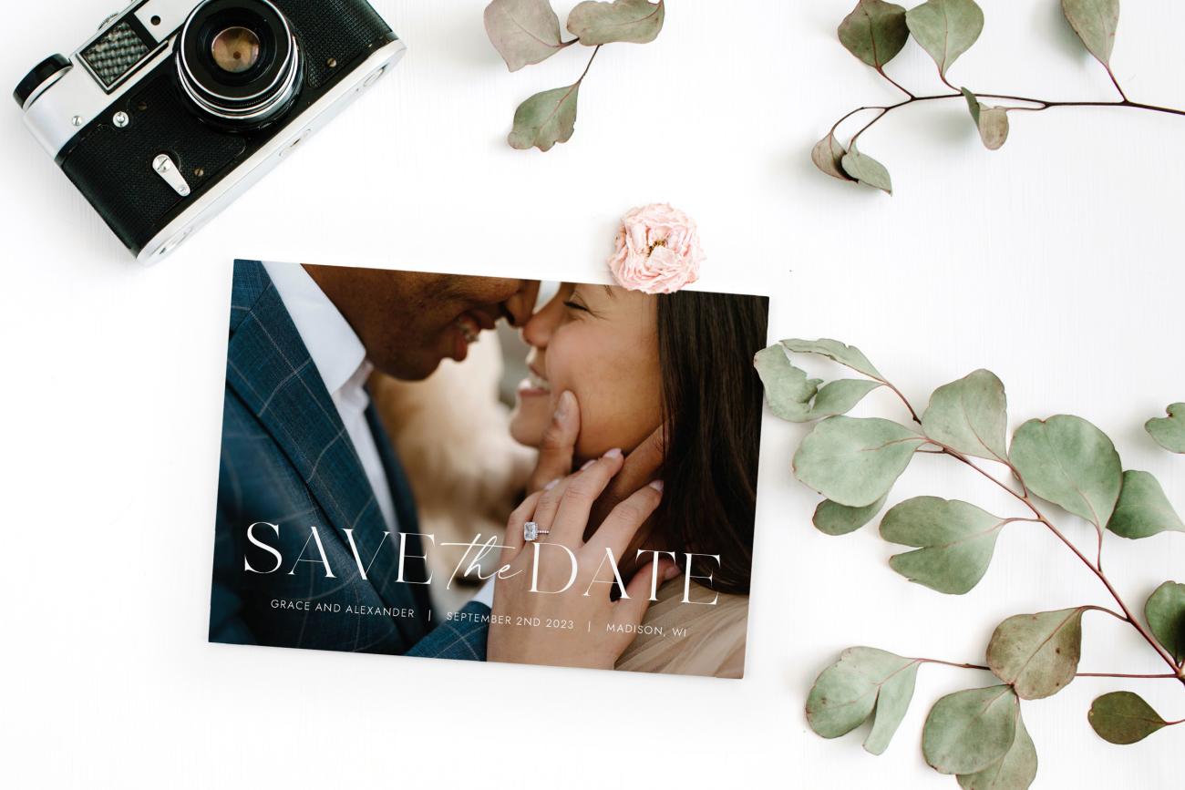 Photo Save the Date with camera and green leaves