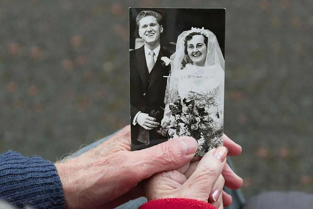 Anniversary Photos - holding wedding photo