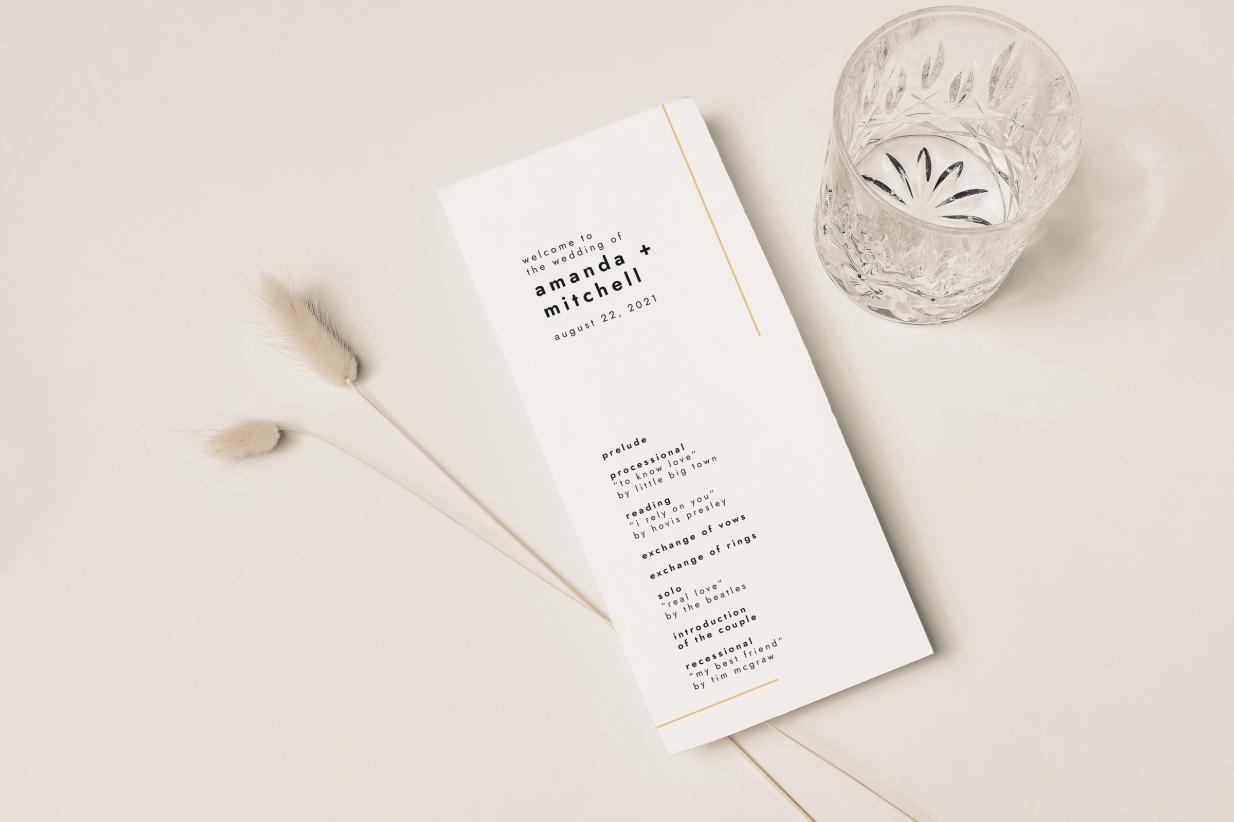 Wedding program sitting on a table with a cup